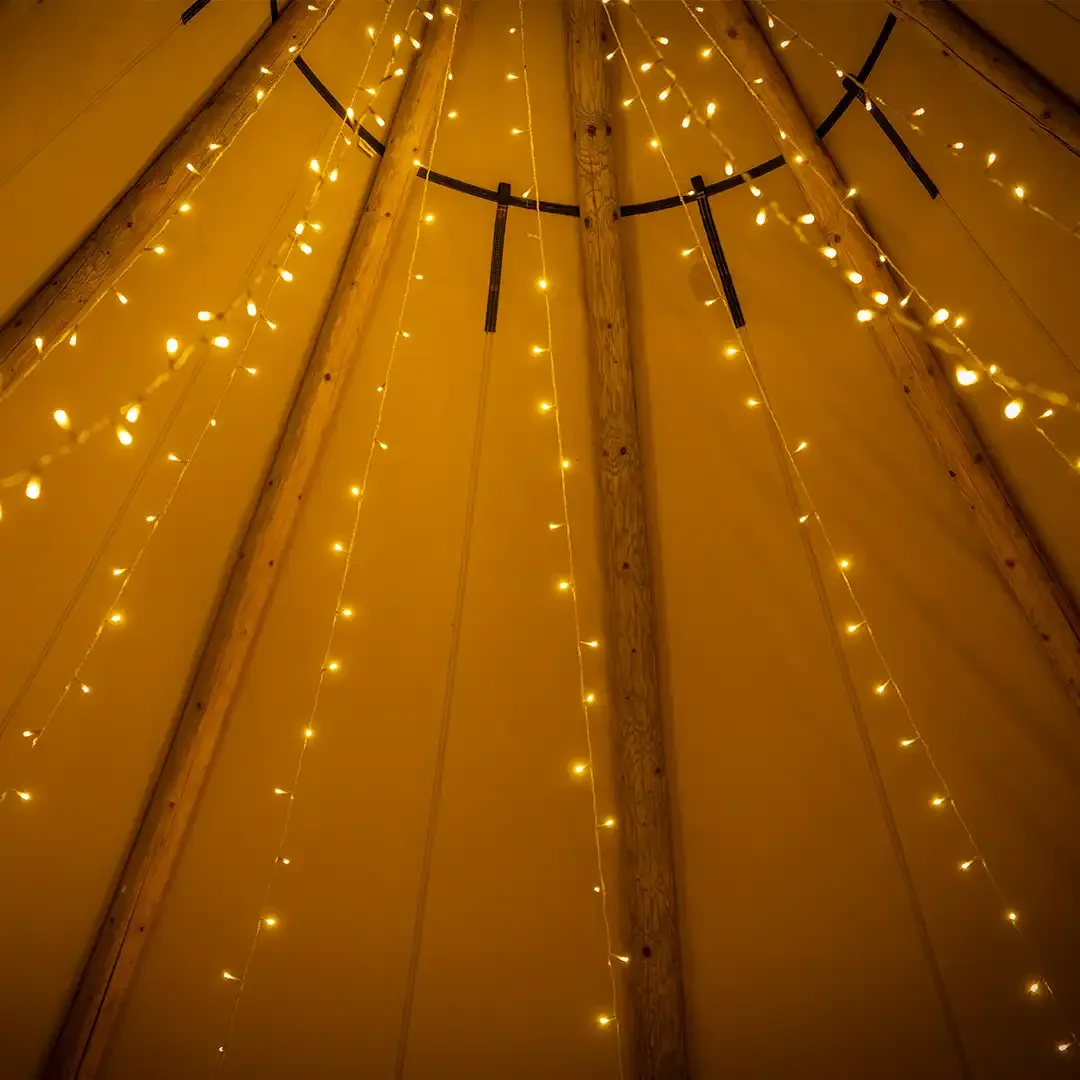 Små lyskæder langs træmasterne op mod tipiens top